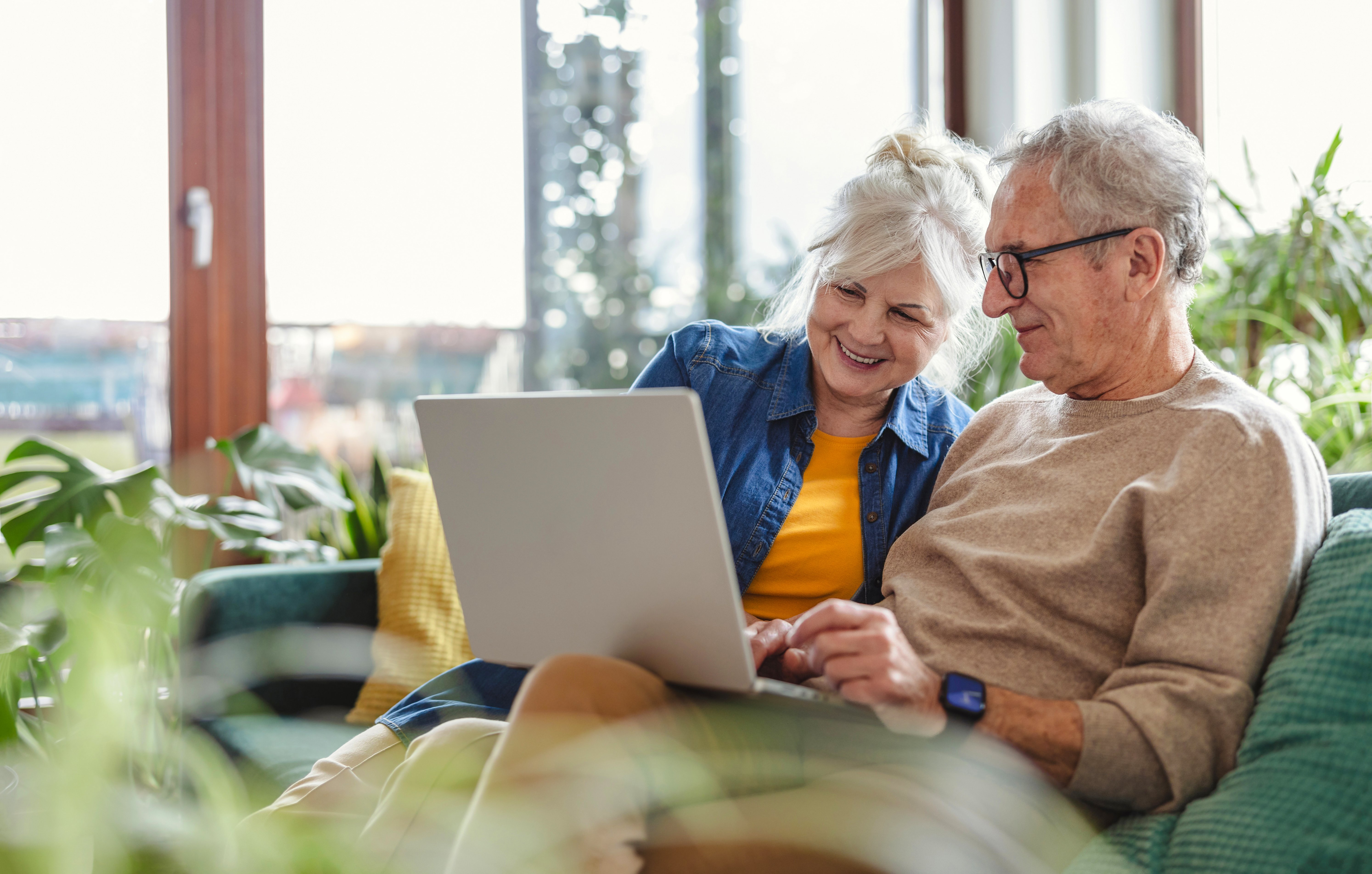 female-european-elderly-indoor-using-laptop-with-her-husband-web